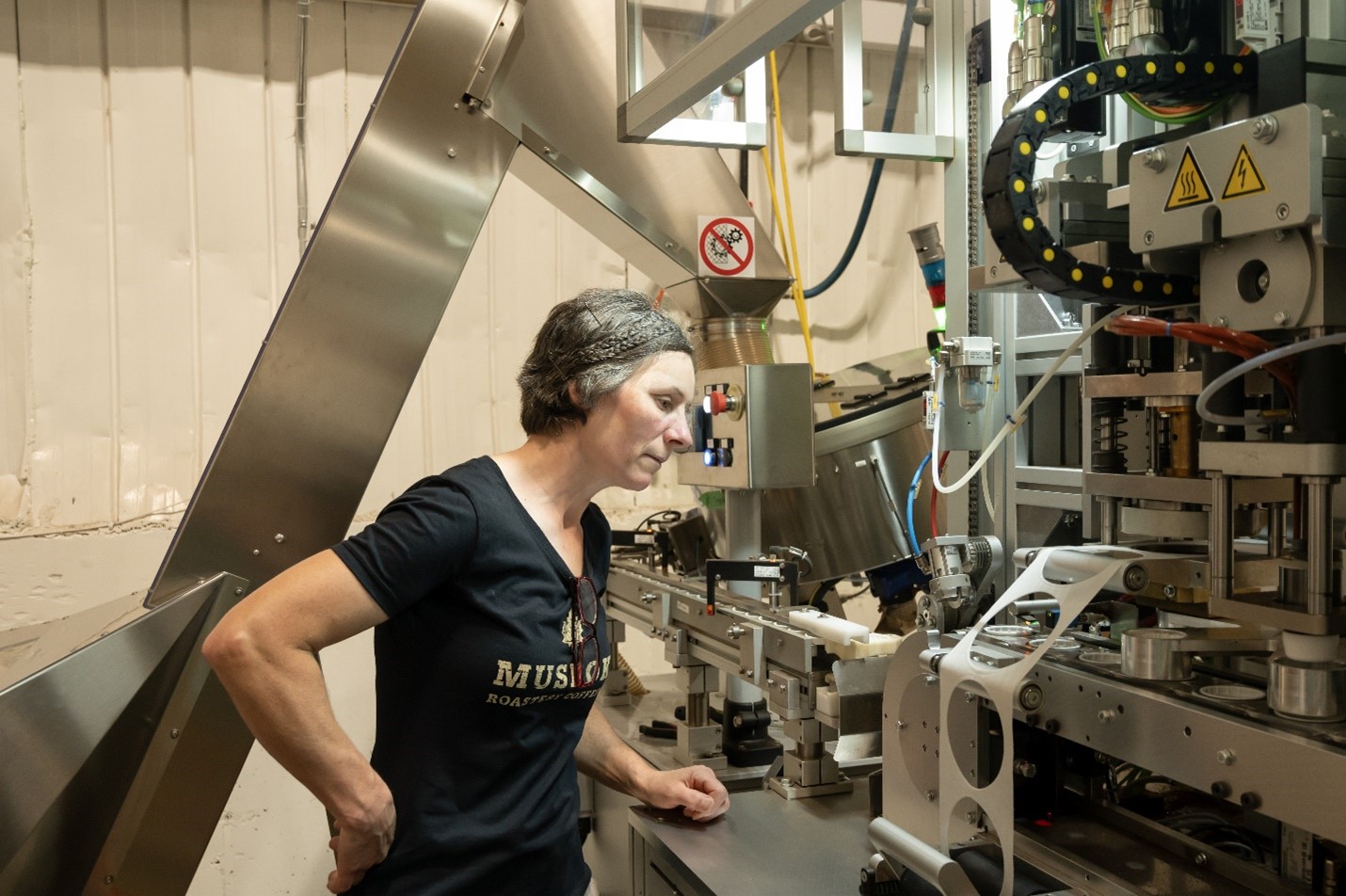 Une femme debout dans une usine, surveillant la production.