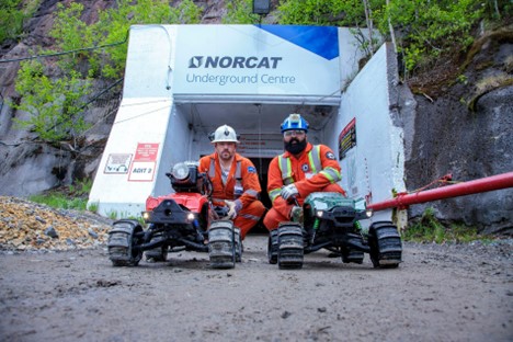 2 Workers, Shawn (NORCAT, Left) and Hrutvik (SafeSight, Right) pictured with two DeepTraxx remote control vehicles, outside of the NORCAT mine at Mining Transformed 2024.