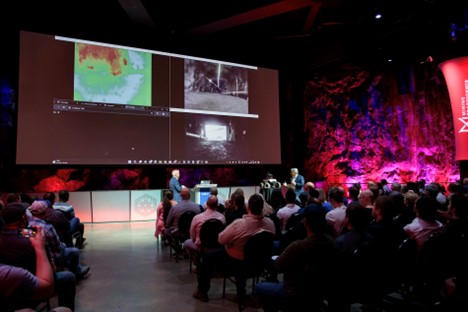 Images from the DeepTraxx's live video and thermal camera being projected onto a screen during a keynote at Mining Transformed 2024.
