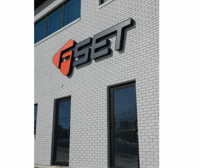 Un bâtiment en briques grises avec un panneau en lettres capitales indiquant FSET